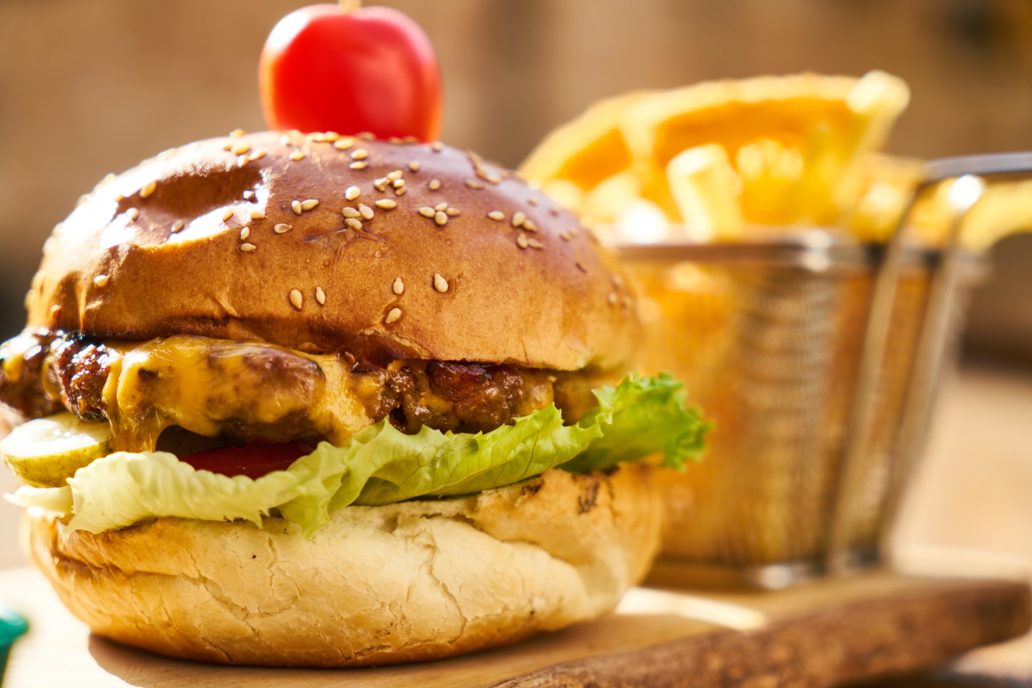 Cheeseburger with lettuce and a basket of crisp fries